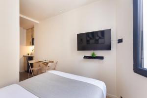 a bedroom with a bed and a flat screen tv on the wall at La Maison Solférino in Boulogne-Billancourt