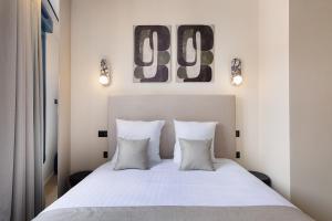 a bedroom with a white bed with two pillows at La Maison Solférino in Boulogne-Billancourt