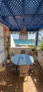 a patio with a table and chairs and a view of the beach at Tiguert serenity in Tiguert