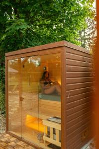 a woman sitting in a tub in a glass house at Lime weekendhouse 1-2 in Balatonakarattya