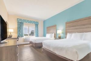 a hotel room with two beds and a television at Amelia Hotel at the Beach in Fernandina Beach