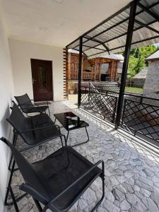 a patio with chairs and a table on a stone floor at DiliOne Guest House in Dilijan