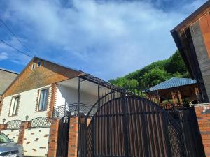 a house with a black gate in front of it at DiliOne Guest House in Dilijan +9 photos