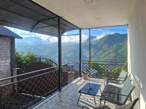 a balcony with two chairs and a table and a view at DiliOne Guest House in Dilijan