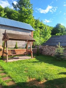 a wooden bench in front of a barn at DiliOne Guest House in Dilijan