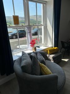 a living room with a couch and a large window at Seaview Aurora House - Central Luxury Apartment in Warrenpoint