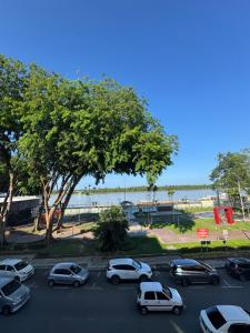 a parking lot with cars parked in front of the water at THE SWAN loft in Sibu
