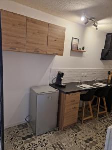 a kitchen with a desk and a small refrigerator at Agréable studio indépendant in Froidfond