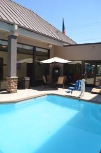 a large swimming pool in front of a house at Comfort Inn & Suites Beaverton - Portland West in Beaverton