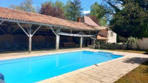 a swimming pool in front of a house at Chambre d'Hôtes Le Moulin Bertrand in Saint-Martin-de-Ribérac