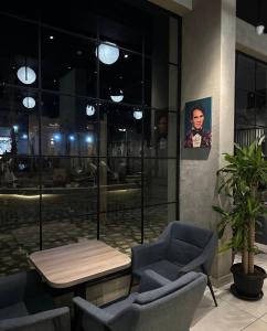 a room with chairs and a table and a picture of a man at City residence in Medina