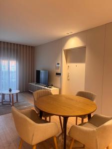 a living room with a table and chairs and a television at Apartamento Cimo da Barca in Ponte da Barca