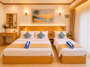 a hotel room with two beds in a room at Handhuvaru Maldives in Milandu