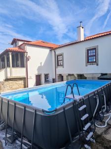 a swimming pool in front of a house at Casa dos Avós in Perre