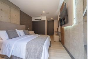a bedroom with a large white bed and a tv at Riomaggiore City Tower in Cali