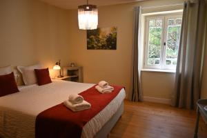 a bedroom with two towels on a bed with a window at Chambre d'Hôtes Le Moulin Bertrand in Saint-Martin-de-Ribérac +22 photos