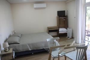 a bedroom with a bed and a glass table at Casas da Gruta - Bungalows in Mira