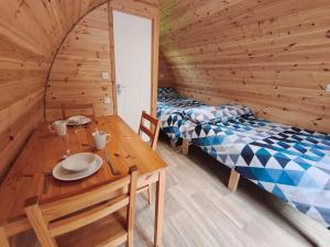 two beds in a wooden room with a wooden table at Barrhill Holiday Park - Glamping in South West Scotland - Stinchar in Girvan