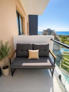 a bench on a balcony with a view of the ocean at Rıversıdelıfe Iskele 164 in Vuda