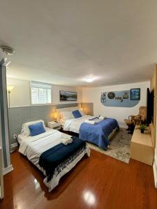 a bedroom with two beds and a television in it at Spacious room near subway & shops in Toronto
