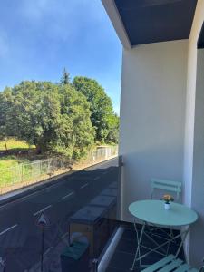 a table on a balcony with a view of a street at Apartamento Cimo da Barca in Ponte da Barca