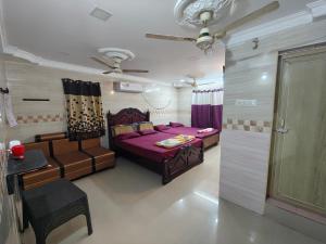 a bedroom with a bed and a couch and a door at SEYONE stay in Kanchipuram