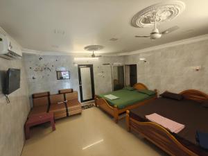 a room with two beds and a tv in it at SEYONE stay in Kanchipuram