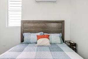 a bedroom with a bed with a wooden headboard at The Mango House in Fajardo +26 photos