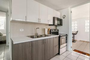 a kitchen with a sink and a microwave at The Mango House in Fajardo