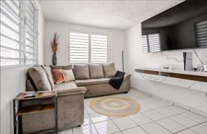 a living room with a couch and a kitchen at The Mango House in Fajardo