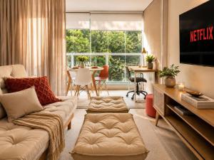 a living room with a couch and a tv at Praça Madá - Anystay in São Paulo