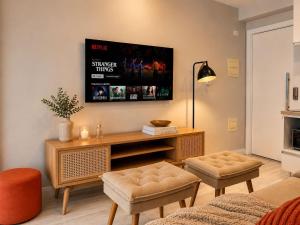 a living room with a table and a tv at Praça Madá - Anystay in São Paulo
