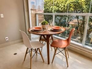 a dining room with a table and chairs and a window at Praça Madá - Anystay in São Paulo