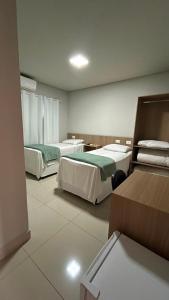 a hotel room with two beds in a room at Mahle Hotel - BR 116, km 48 in Campina Grande do Sul