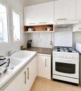 a white kitchen with a stove and a sink at Chic & Comfortable Stay in Monastir