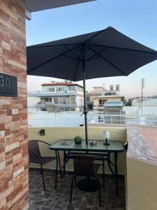 a table with an umbrella on a patio at Cozy Rhodes Studio in Rhodes Town