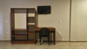 a chair sitting at a desk with a television at Hotel Recife in Ciudad del Este