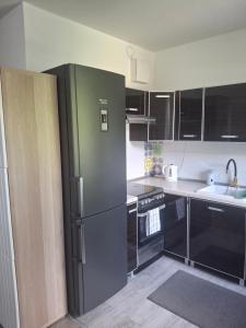 una cucina con frigorifero in acciaio inox e mobili neri di Easy a Gdynia Altre 9 foto