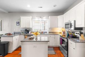 a kitchen with white cabinets and granite counter tops at Backyard Hangout Firepit Giant Connect 4 & BBQ in Raleigh