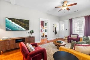 a living room with red chairs and a ceiling fan at Backyard Hangout Firepit Giant Connect 4 & BBQ in Raleigh +27 photos