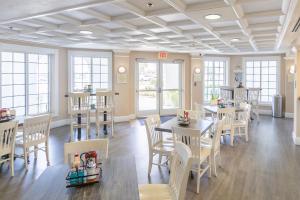a dining room with tables and chairs and windows at Amelia Hotel at the Beach in Fernandina Beach