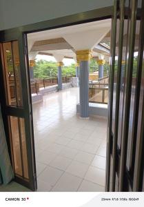 an open glass door of a building with columns at sea flower in Lomé