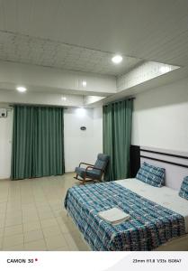 a bedroom with a bed and two chairs in it at sea flower in Lomé