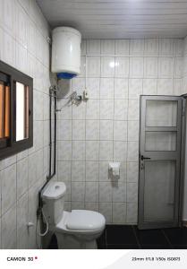 a bathroom with a toilet and a light on the wall at sea flower in Lomé +24 photos
