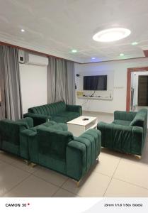 a living room with green couches and a tv at sea flower in Lomé