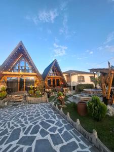 a large house with a stone patio in front of it at Toma's Nest-თომას ბუდე in Martvili
