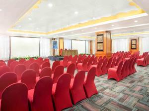 a conference room with red chairs and a podium at Novotel Solo in Solo +60 photos