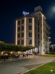 a tall white building with tables in front of it at Hotel Restaurant Globi in Velipojë