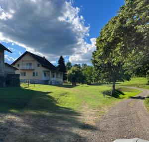 a house with a tree and a dirt road at Eko Haus Tesla in Srnava
