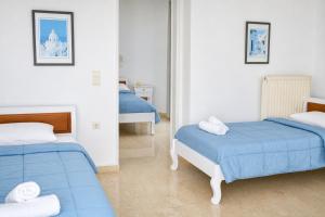 a bedroom with two beds and a mirror at New Haroula in Fira
